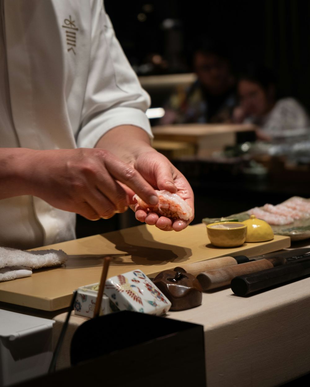 Chef's hands preparing sushi with care