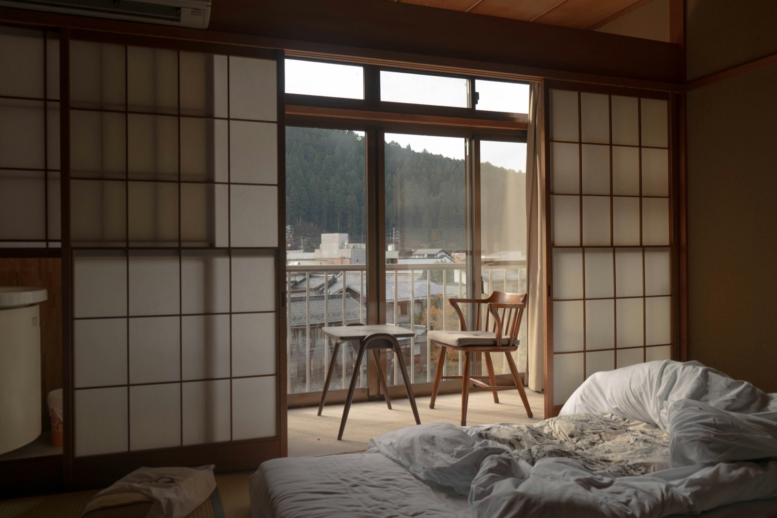 A traditional ryokan room with shoji screens and a mountain view
